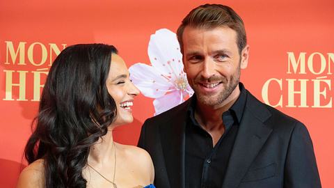 Amira Aly lacht breit und schaut zur Seite. Christian Düren steht breit lächelnd neben ihr. - Foto: IMAGO / Future Image