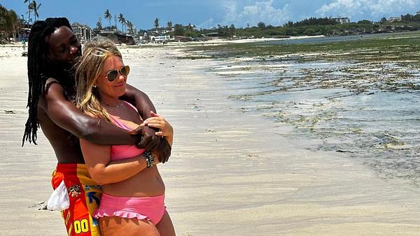 Amore unter Palmen Stars: Claudia und Rolence umarmen sich am Strand - Foto: Joyn