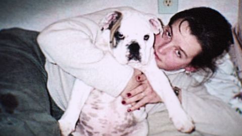 Amy Bradley hält einen Hund im Arm und schaut in die Kamera in einem alten Foto - Foto: Netflix
