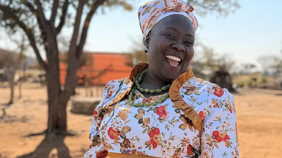 Anastasia kommt aus Namibia. Anastasia lächelt und steht in einer Wüstenlandschaft.