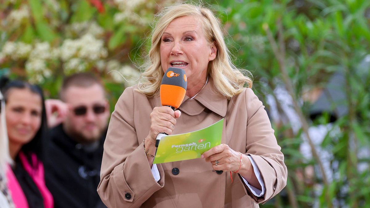 Nicht dasd erste Mal, dass Andrea Kiewel ein Missgeschick mit ansieht. Andrea Kiewel im Trenchcoat während einer Moderation im Fernsehgarten.