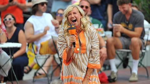 Andrea Kiewel im fernsehgarten - sie lacht mit einem Mikrofon in der Hand - Foto: IMAGO / STAR-MEDIA
