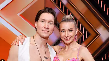 Anna-Carina Woitschack und Evgeny Vinokurov stehen im Lets Dance-Studio nebeneinander und lächeln in die Kamera. - Foto: IMAGO / Panama Pictures