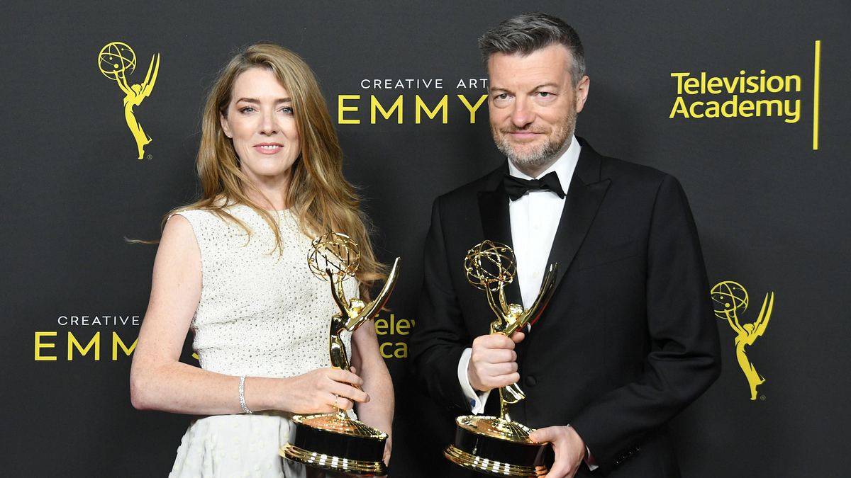 Annabel Jones und Charlie Brooker sind dank „Black Mirror“ bei den Emmys keine Unbekannten. Annabel Jones und Charlie Brooker halten jeweils einen Emmy und lächeln in die Kamera.
