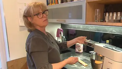Annett steht in ihrer Küche und bereitet mit einer Nudelmaschine frischen Teig für ihr Dinner-Menü zu. - Foto: RTL+/Screenshot