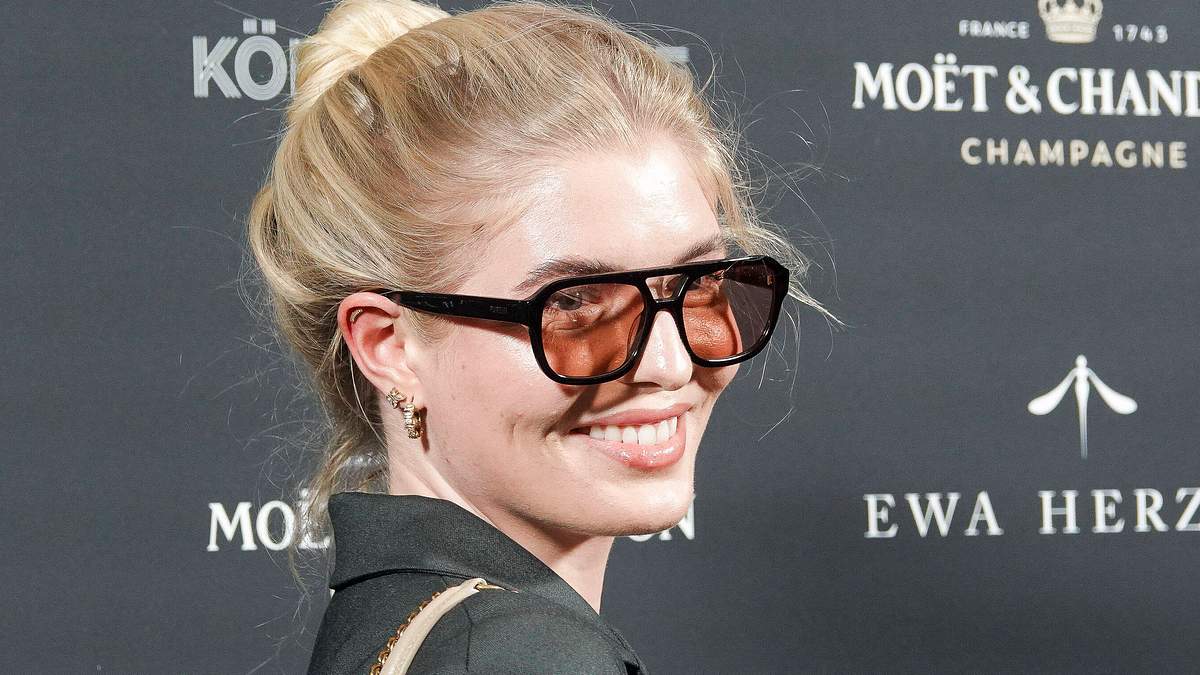 Antonia Hemmer mir orangener Sonnenbrille und Dutt auf einem Event.