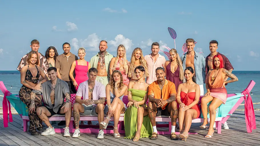 AYTO VIP Cast 2026 AYTO VIP Cast 2026 in bunter Sommerkleidung posiert auf und hinter einer türkis-rosa Bootsbank auf einem Holzsteg am Meer.