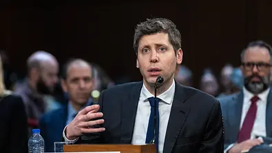 Sam Altman spricht öffentlich an einem Tisch. Vor steht ein Schild mit seinem Namen. - Foto: IMAGO / UPI Photo Sam Altman spricht öffentlich an einem Tisch. Vor steht ein Schild mit seinem Namen. - Foto: IMAGO / UPI Photo