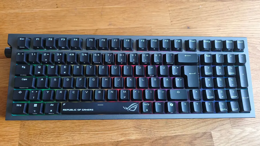 ASUS ROG Strix Morph 96 Wireless Eine ASUS ROG Strix Morph 96 Wireless ist auf einem Holztisch