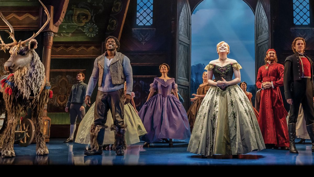 Die Besetzung von „Frozen: The Hit Broadway Musical“ steht auf der Bühne und lächelt ins Publikum.