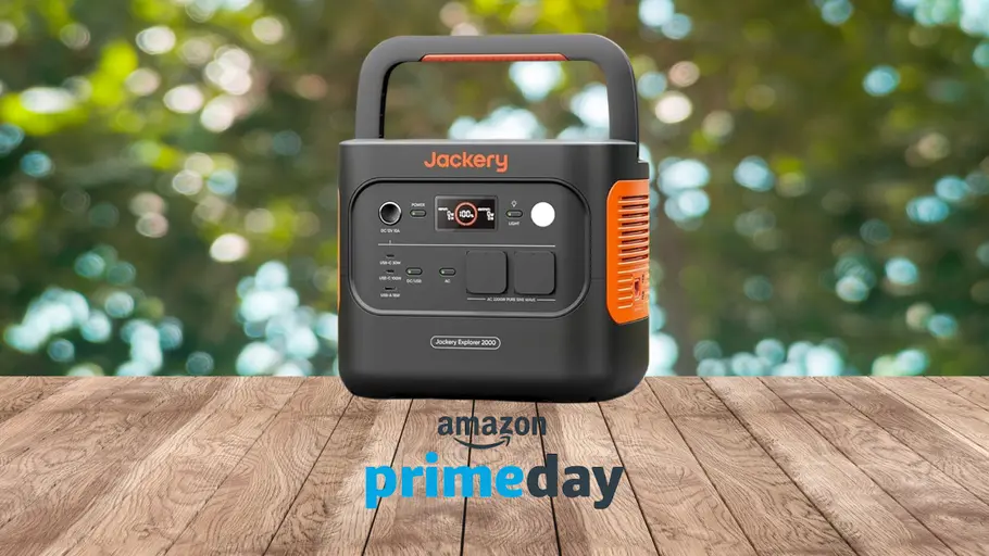 Aufmacherbild Pre Prime Day tragbare Powerstation Jackery E2000 v2 tragbare Powerstation auf einem Gartentisch aus Holz, im leicht verschwommenen Hintergrund ein Baum