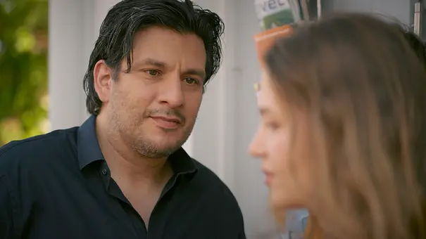 Maximilian trägt ein dunkles Hemd und blickt Nathalie an, die rechts unscharf im Profil zu sehen ist. - Foto: RTL