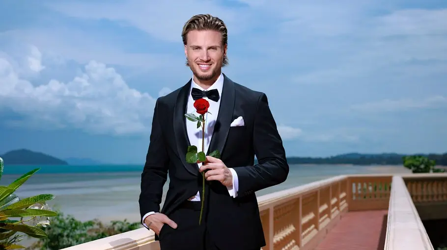 Danilo ist der aktuelle Bachelor in der Schweiz. Danilo mit Anzug und Rose in der Hand.
