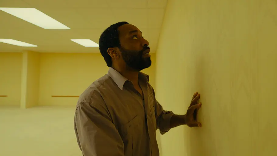 Backrooms Chiwetel Ejiofor tastet mit seinen Händen an den vergilbten Wänden der Backroooms entlang.