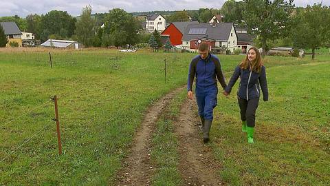 Das „Bauer sucht Frau“-Paar Paul und Anna spaziert Hand in Hand über eine Wiese. Die beiden wollen den nächsten Schritt wagen. - Foto: RTL