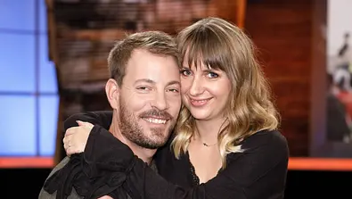 Anna und Gerald Heiser halten sich in den Armen und lächeln in die Kamera. - Foto: IMAGO / Future Image