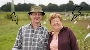  „Bauer sucht Frau“-Traumpaar Walter und Katharina lächeln in die Kamera - neben ihnen sind zwei Blitz-Symbole. - Foto: RTL/Stefan Gregorowius/ Canva