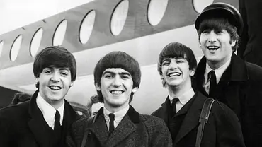 Die Beatles stehen vor einem Flugzeug und lachen in die Kamera. - Foto: IMAGO / Cinema Publishers Collection