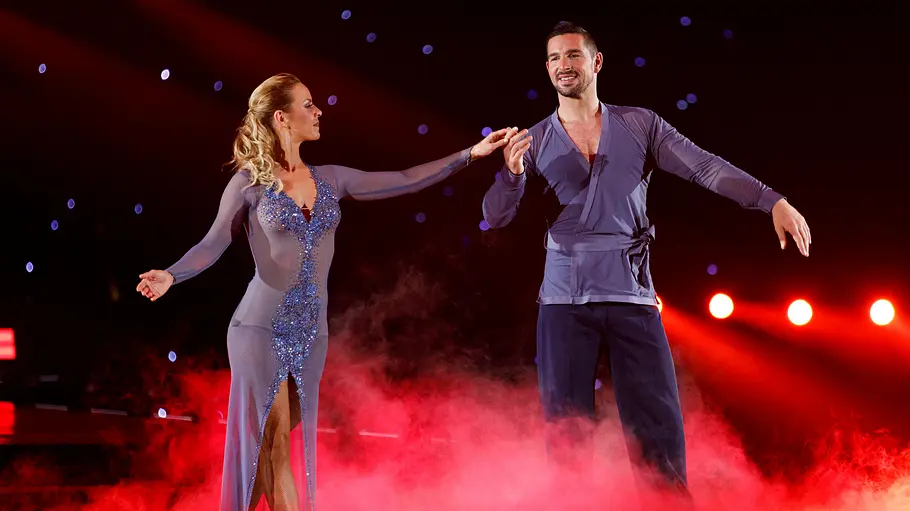 Benjamin Piwko und Isabel Edvardsson tanzen gemeinsam auf der Bühne der Show „Let’s Dance“ vor rotem Nebel