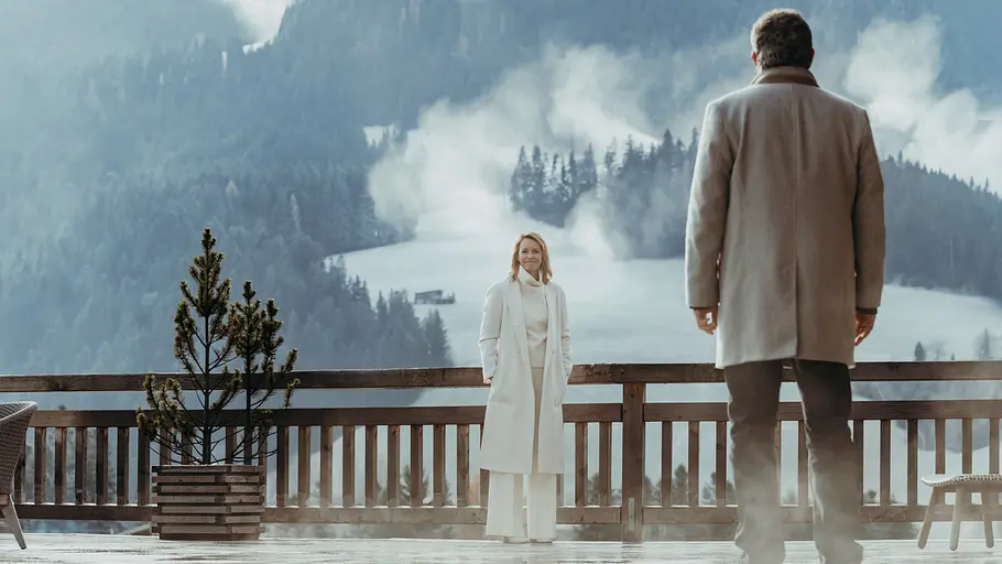 Martin steht Franziska vor einem Bergpanorama gegenüber.