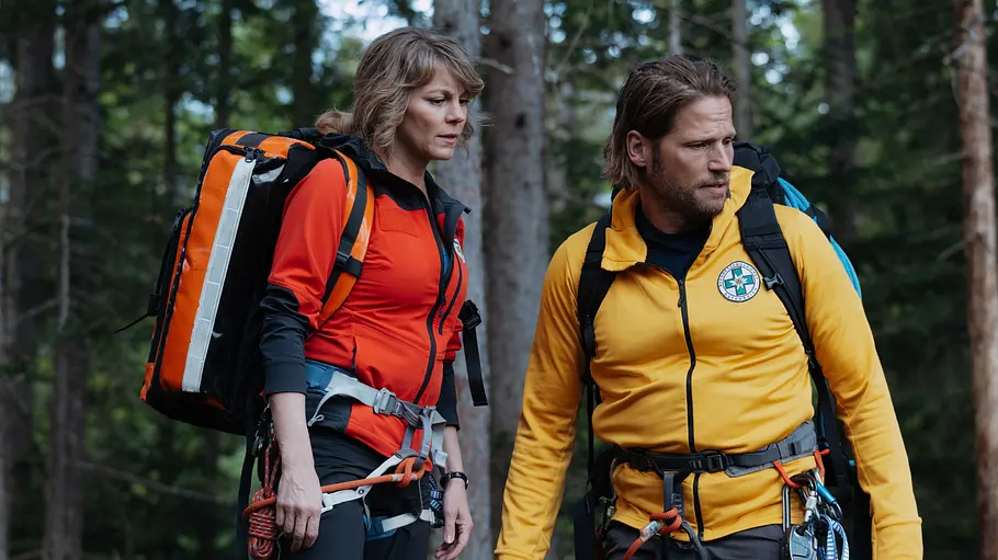 Markus sorgt sich um Katharina. Die Bergretter Markus (Sebastian Ströbel) und Katharina (Luise Bähr) stehen nebeneinander und blicken fragend auf etwas außerhalb des Bildausschnitts.