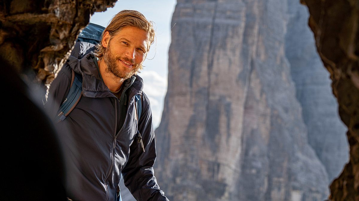 Sebastian Ströbel lächelt in „Die Bergretter“ in die Kamera.