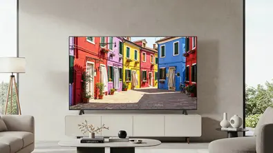 Vor einer grauen Wand in einem Wohnzimmer steht ein Fernseher auf einem Sideboard. - Foto: LG/ PR