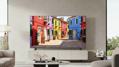 Vor einer grauen Wand in einem Wohnzimmer steht ein Fernseher auf einem Sideboard. - Foto: LG/ PR