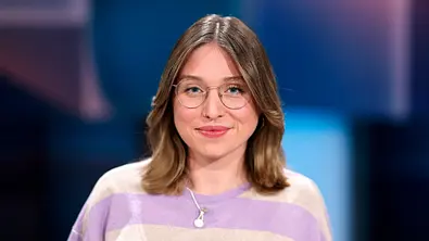 Bianca Heinicke bei einem Event: Sie trägt eine Brille sowie einen lila-beige gestreiften Pullover und lächelt in die Kamera. - Foto: IMAGO / Panama Pictures