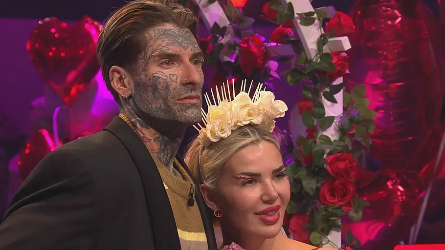 Promi Big Brother Kim Virginia Nikola Nikola und Kim Virginia mit Blumenkrone stehen eng beieinander vor roten Rosen und Herzballons.