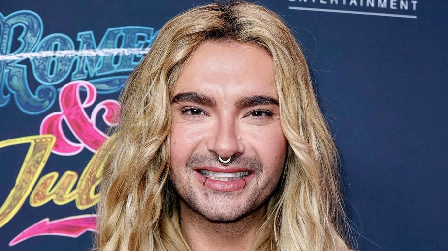 Bill Kaulitz lächelt bei der Premiere des Musicals „& Julia“ in die Kamera.