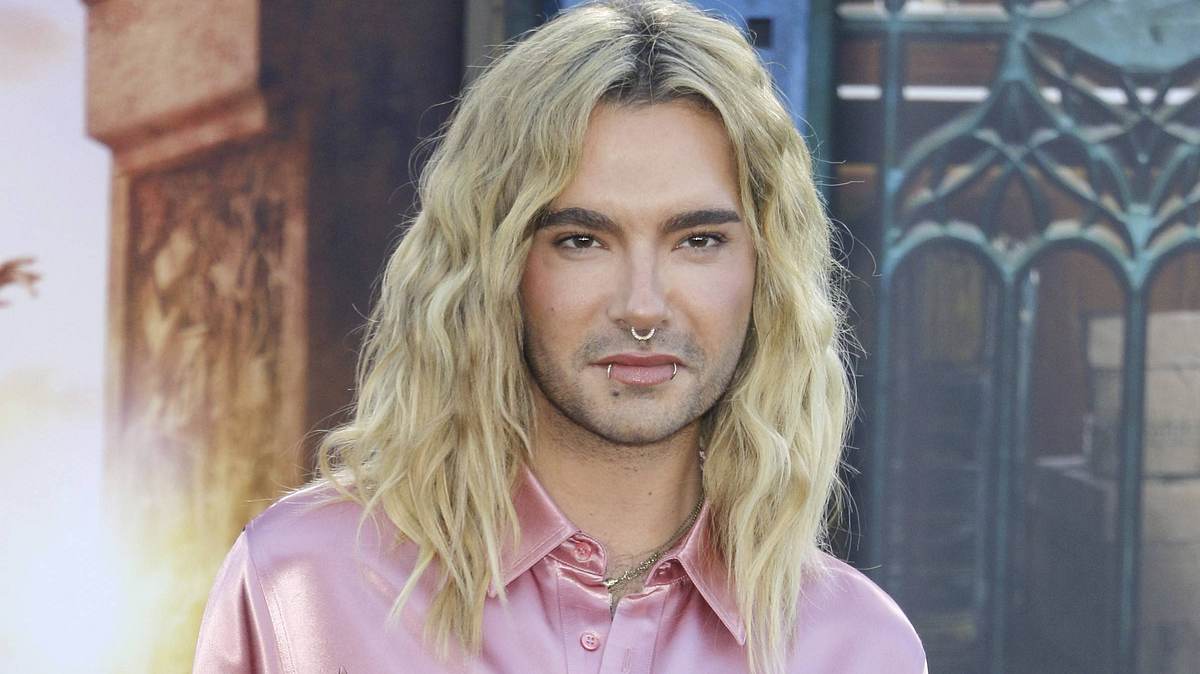 Bill Kaulitz schaut leicht lächelnd in die Ferne