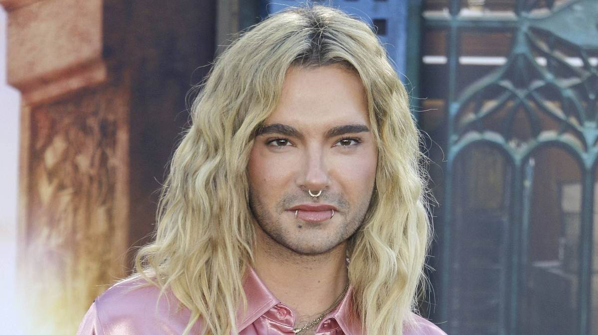 Bill Kaulitz Bill Kaulitz posiert in einem rosafarbenen Seidenhemd.