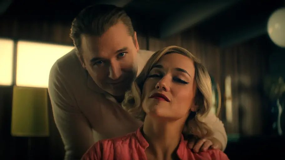 Blaine steht hinter Anneliese, sie schauen beide in die Kamera.