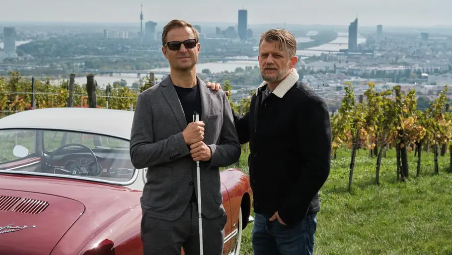 „Blind ermittelt: Tod im Weinberg“: Haller und Niko ermitteln in Grinzing Philipp Hochmair und Andreas Guenther in „Blind ermittelt: Tod im Weinberg“ vor einem Oldtimer in den Wiener Weinbergen