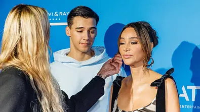 Diego Pooth und Verona Pooth stehen vor einer blauen Wand. Eine blonde Frau richtet Verona die Haare. - Foto: IMAGO / Oliver Langel