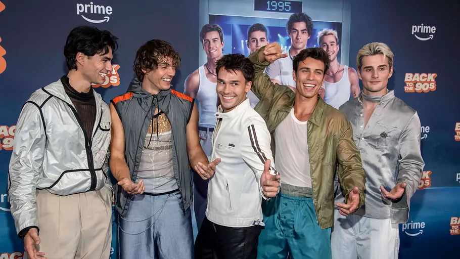 Elevator Boys Fünf Mitglieder der Elevator Boys stehen nebeneinander vor einer hellen Pressewand und posieren für die Kamera.
