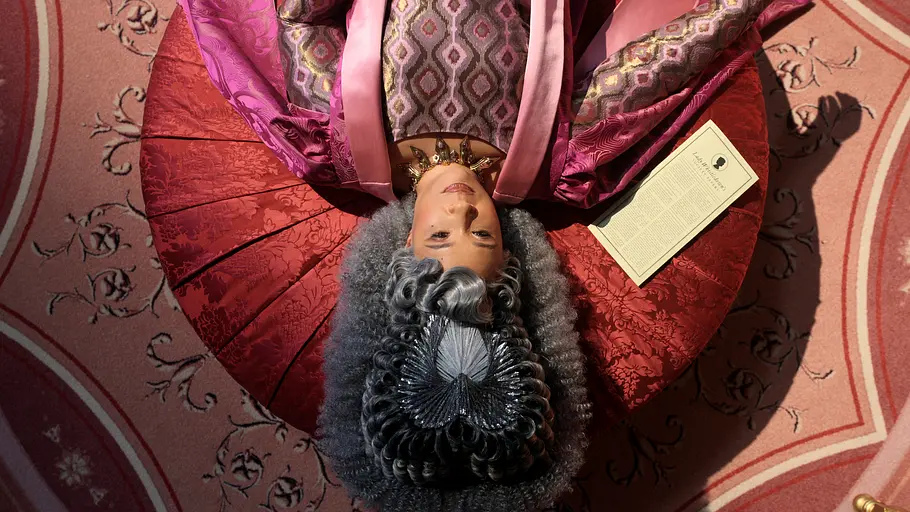 Queen Charlotte liegt gelangweilt auf einem Divan. Die neueste Ausgabe von Lady Whisltedown liegt neben ihr.