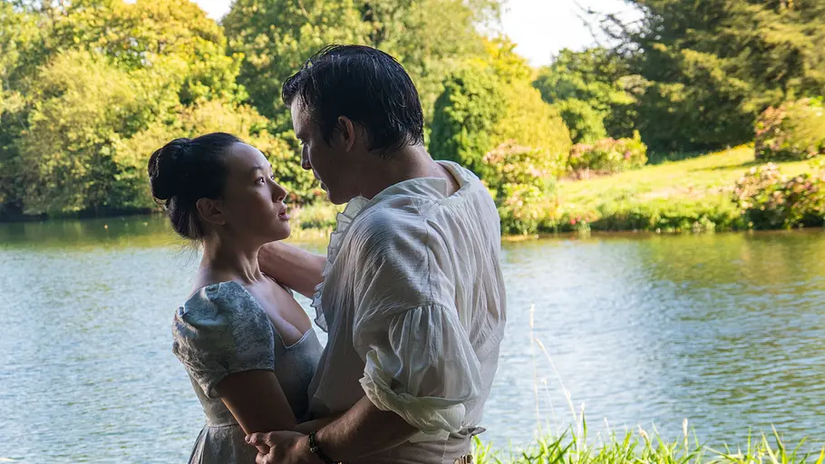 Sophie (Yerin Ha) und Benedict (Luke Thompson) umarmen sich in „Bridgerton“ Staffel 4 und sind kurz davor sich zu küssen.