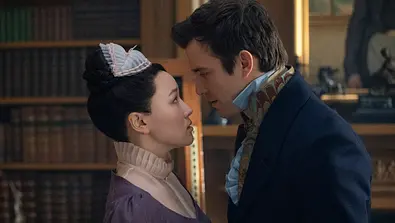 Sophie (Yerin Ha) und Benedict (Luke Thompson) in der 4. Staffel von „Bridgerton“ stehen nah voreinander und sind kurz davor sich zu küssen. - Foto: Liam Daniel/Netflix
