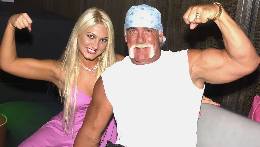Hulk und Tochter Brooke im pinken Kleid und posieren nebeneinander und zeigen ihre Arme.