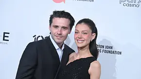 Brooklyn Beckham und Victoria Peltz stehen vor einer Fotowand und lächeln in die Kamera. - Foto:  IMAGO / ZUMA Press