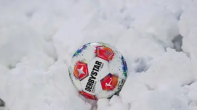 Ein Bundesliga Ball steckt im Schnee fest! - Foto: IMAGO / Eibner