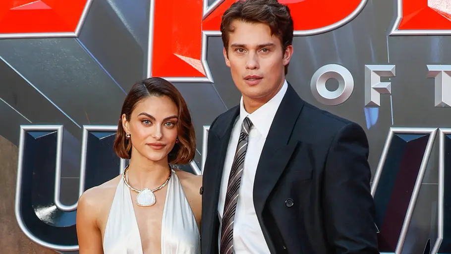 Camila Mendes und Nicholas Galitzine posieren auf einem roten Teppich vor einer großen „Masters of the Universe“-Premierenwand.