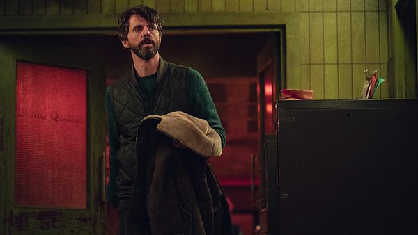 Carl Morck steht vor einer offenen Tür und hält seine Jacke in der Hand. - Foto: Jamie Simpson/Netflix