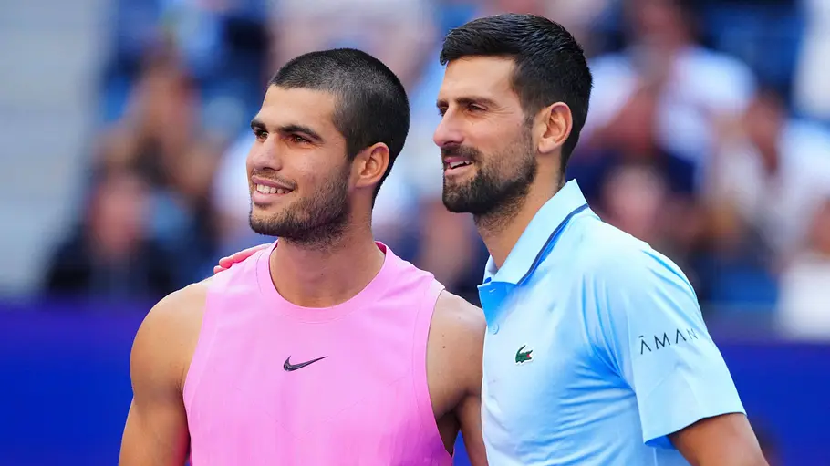Carlos Alcaraz und Novak Djokovic Carlos Alcaraz und Novak Djokovic stehen bei den US-Open nebeneinander und lächeln.