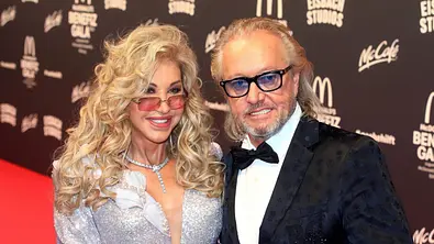 Carmen und Robert Geiss tragen beide getönte Sonnenbrillen und edle Kleidung auf dem roten Teppich. - Foto: IMAGO / Future Image Carmen und Robert Geiss tragen beide getönte Sonnenbrillen und edle Kleidung auf dem roten Teppich. - Foto: IMAGO / Future Image