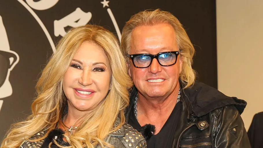 Carmen und Robert Geiss stehen dicht beieinander und lächeln breit. Er trägt eine Sonnenbrille.