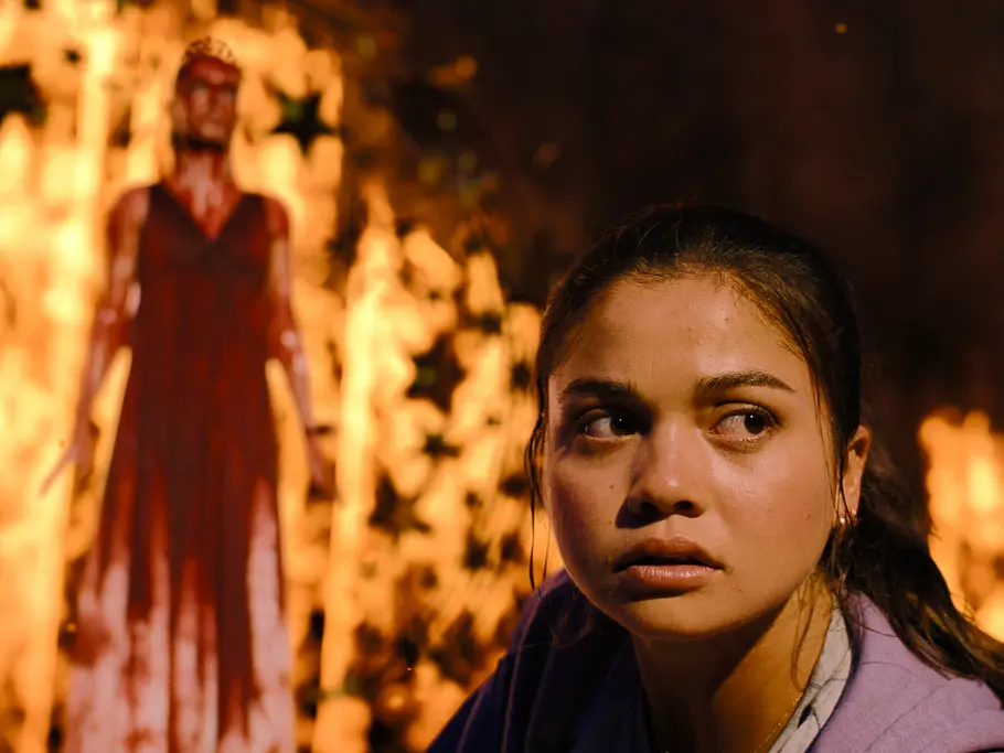 Carrie auf Prime Video: Unterschied Roman Siena Agudong als Sue Snell schaut sich um, während die blutüberströmte Carrie (Summer H. Sowell) im Hintergrund vor Flammen steht.