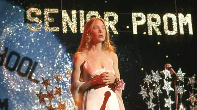 Man sieht Sissy Spacek als titelgebender Charakter aus dem Film „Carrie“ aus dem Jahr 1976 von Brian De Palma. Sie trägt ein rosa Abschlusskleid auf und ist auf einem Abschlussball. Im Hintergrund glänzt der Schriftzug „Senior Prom“.  - Foto: IMAGO / Cinema Publishers Collection